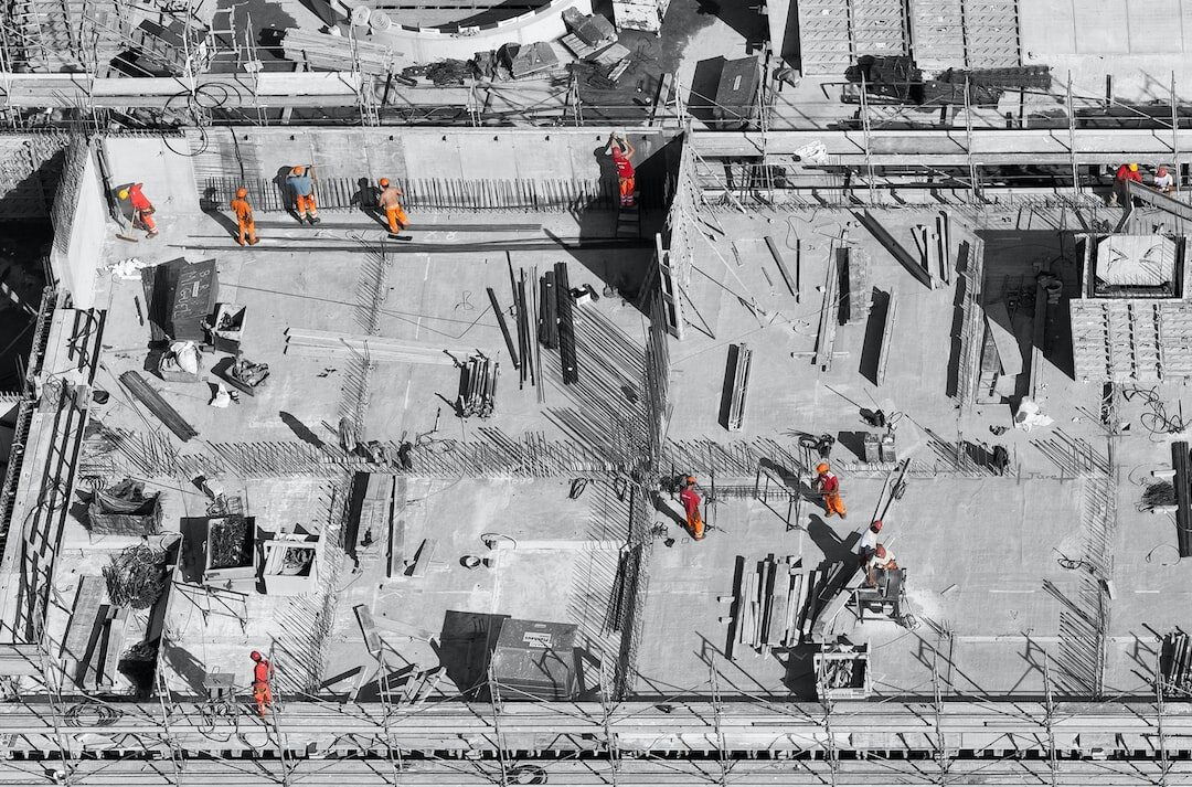 Vista aérea de obra con equipo técnico inspeccionando